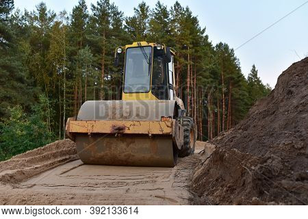 Vibro Roller Soil Compactor At Road Construction And Bridge Projects In Forest Area. Heavy Machinery