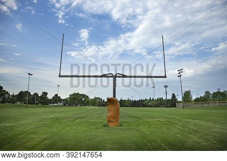 Wide Angle View Of A Goalpost On A Football Field With Beautiful Clouds In The Morning