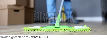 Close-up Of Male Hands Holding Microfiber Fluffy Rag And Mopping Floors. Cleaning Apartment After Mo
