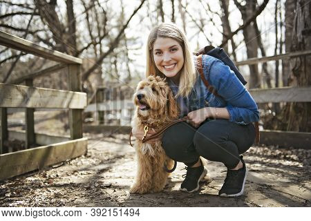 Happy Labradoodle Dog And Woman Outside At The Park