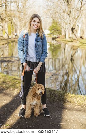Happy Labradoodle Dog And Woman Outside At The Park