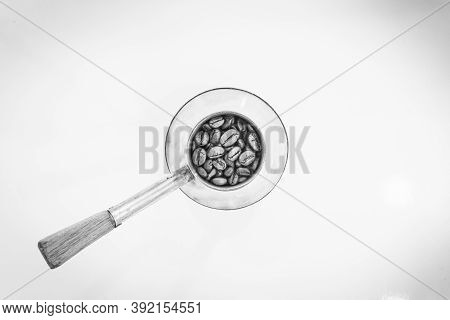Black And White Image Of Coffee Beans In Vintage Coffee Pot In White Background.