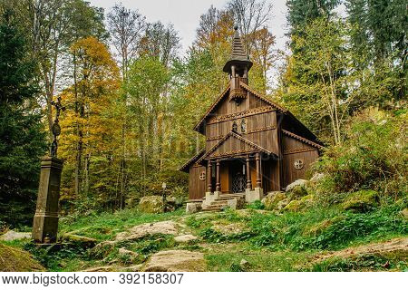 Old Wooden Pilgrimage Rural Chapel Of Virgin Mary, Cz: Stozecka Kaple, And Iron Cross, Standing In A