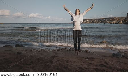 Young Caucasian Brunette Woman Doing Youga On The Sandy Beach In The Morning. High Quality Photo