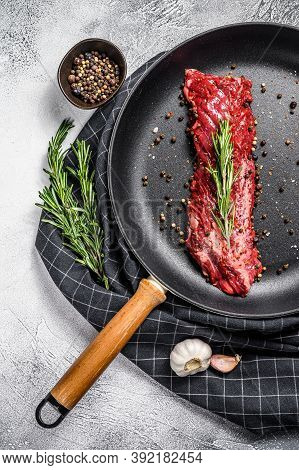 Raw Strip Vegas Steak In A Pan With Cooking Ingredients. Gray Background. Top View