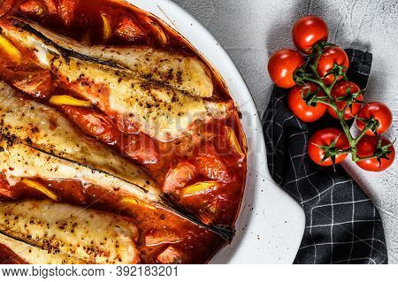 Cooking In Tomatoes Monkfish Fish In A Baking Dish. Fresh Seafood. Gray Background. Top View