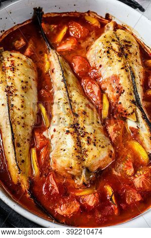 Monkfish Baked In Tomatoes In A Baking Dish. Black Background. Top View