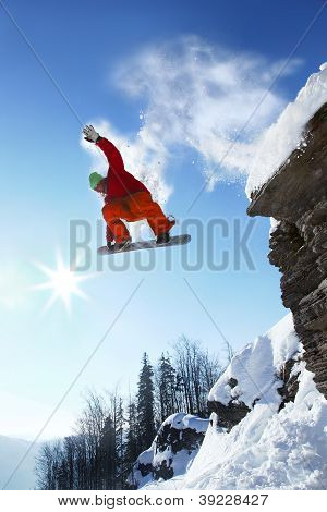 Snowboarder springer mod blå himmel