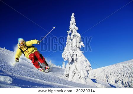Skier skiing downhill in high mountains