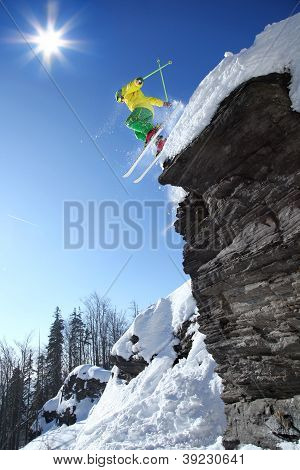 Skier jumping against blue sky from the rock