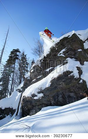 Snowboarder jumping against blue sky
