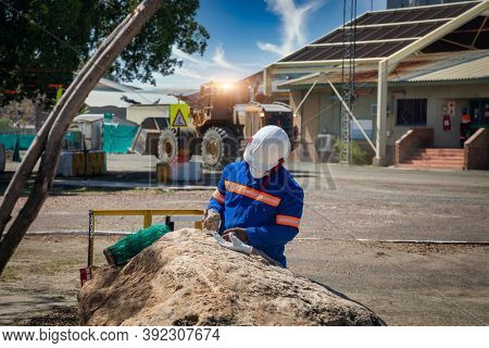 Industrial background, diamond mine in Africa, technician checking kimberlite and earthmoving machines in the back