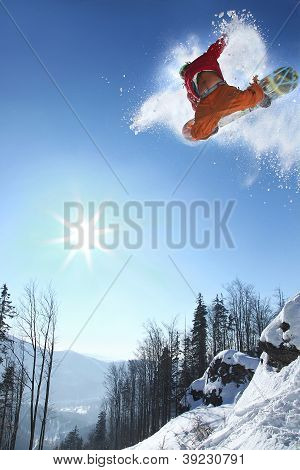 Snowboarder springer mod blå himmel