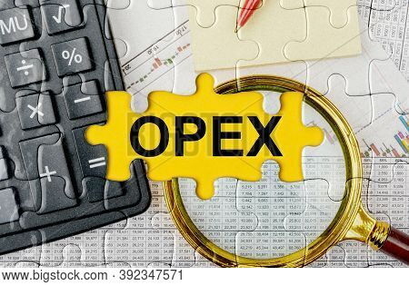 Business Concept. Puzzle With A Calculator, Magnifying Glasses And Financial Documents In The Center