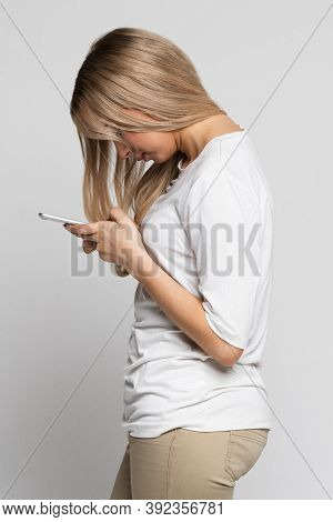 Caucasian Female Using Mobile Phone With Scoliosis, Side View. Rachiocampsis, Kyphosis Curvature Of 