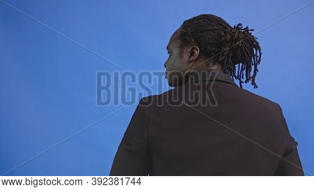 Back View Of African American Black Man Isolated On Blue Background. High Quality Photo