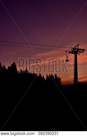 Ski Chair Lift In The Mountains At Beautiful Sunset. Vertical Photo.