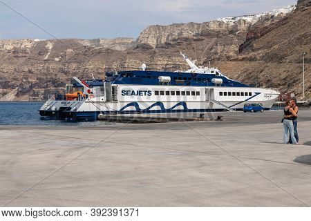 Ormou Athiniou, Santorini Island, Greece- 19 2020: View Of The New Harbor Of Thira. Passenger Ferry 