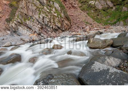 Long Exposure Of The River Heddon Flowing Onto The Beach At Heddons Mouth In Exmoor