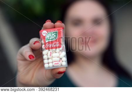 Young Girl Holds Tic-tac Hard Mints Pack With Coca-cola Taste. Tic Tac Is A Brand Of Small Hard Mint