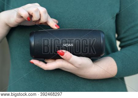 Young Girl Holds Nomi Black Portable Usb Speaker By Nomi Electronics Company. New Outstanding Mobile