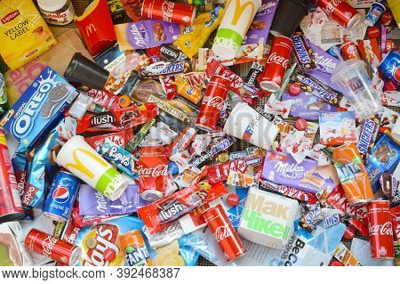 Many Wrappings And Cans From Used Products By Famous Worldwide Brands. Pattern Of Trash Of Various C