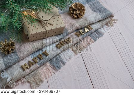 Wooden Background With A Warm Blanket And Gold Letters And A Gift Box. Space For Text.
