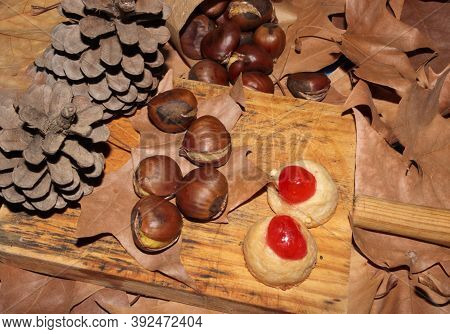 Chestnuts And Panellets With Pinecones And Dried Leaves, Autumn Motif And Chestnut Festival