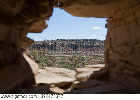 The Dry Rocky Landscape Of Chaco Canyon As Seen Through A Window Built Into An Ancient Rock Building