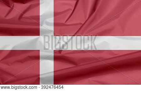 Fabric Flag Of Denmark. Crease Of Danish Flag Background, Red With A White Scandinavian Cross That E