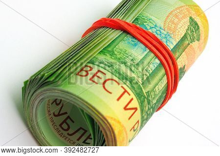 A Rolled Up Bundle Of Russian Banknotes Of 200 Rubles Lies On A White Paper Background. Denomination