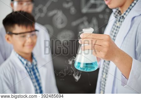 Teacher Showing Flask With Smoking Blue Liquid To School Students When Explaining Chemical Reaction 
