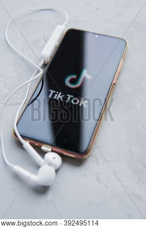 Tver, Russia-february 12, 2020 Tik Tok Logo On The Smartphone Screen And White Wireless Headphones O