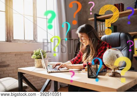 Woman Teleworker Works At Home With A Laptop With A Lot Of Questions. She Is In Smart Working Due To