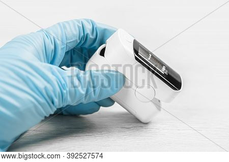 Medical Concept. Pulse Oximeter In Hand. Medical Protective Glove. Pneumonia, Covid Prevention And C