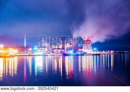 A Panoramic View Of The Pipes And Cooling Towers Of The Chp. Industry District At Night, Reflection 