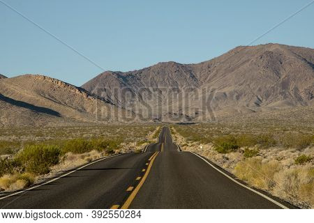 Wavy Road And Some Mountains In The Background In Death Valley In The Usa