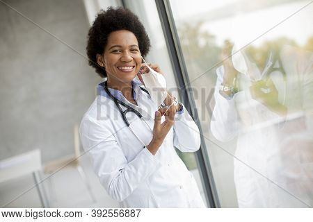 Female African American Docor Wear White Uniform And Taking Off Face Mask