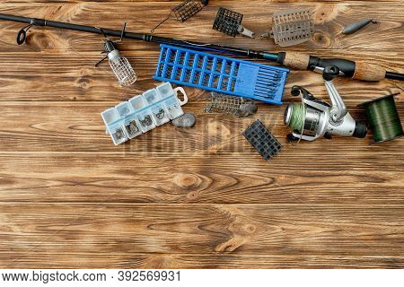 Flat Lay With Fishing Tackle, Fishing Rod And Plastic Box With Fishing Tackle And Hooks, Feeders On 