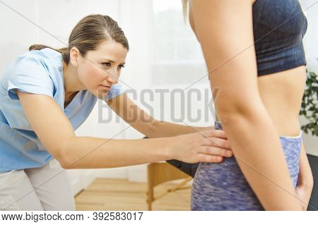 A Modern Rehabilitation Physiotherapist At Work With Client. Working On Lower Back.