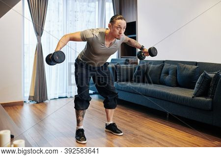 Fit Mixed-race Man Doing Dumbbell Flys When Working On His Chest, Shoulder And Triceps Muscles
