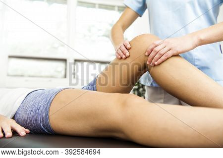 A Modern Rehabilitation Physiotherapist At Work With Client. Working On Knee