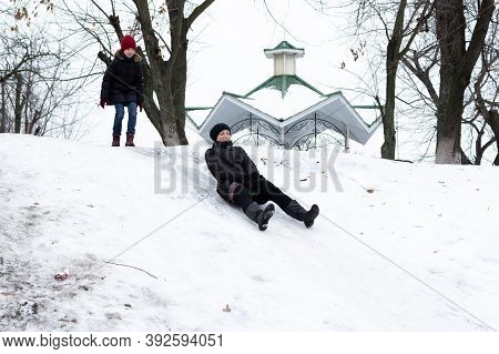 Mom And Daughter Ride A Slide. Winter Fun On The Slide. Winter Skiing.