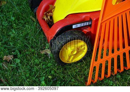Autumn Accessories For Working In The Garden.tial Areas. Lawn Mower And Rake.