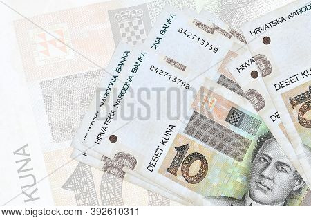 10 Croatian Kuna Bills Lies In Stack On Background Of Big Semi-transparent Banknote. Abstract Presen