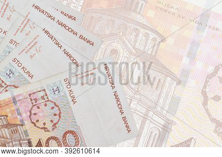 100 Croatian Kuna Bills Lies In Stack On Background Of Big Semi-transparent Banknote. Abstract Busin