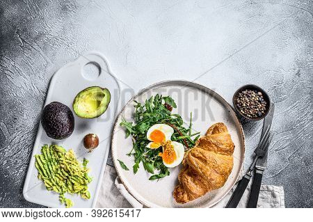 Salad With Avacado, Arugula, Croissant And Egg. Gray Background. Top View. Space For Text