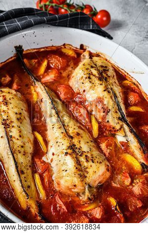 Cooking In Tomatoes Monkfish Fish In A Baking Dish. Fresh Seafood. Gray Background. Top View