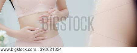 Beautiful Young Asian Woman In Underwear Looking Mirror Applying Cream And Lotion On Belly, Beauty G