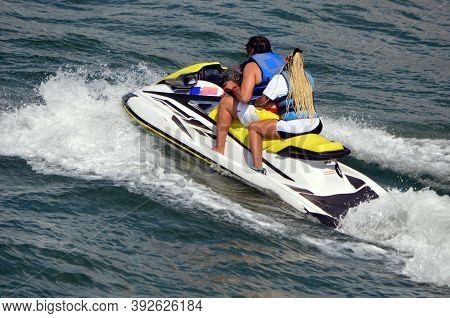 Afro American Man And Woman Riding Tandem On A Jetski